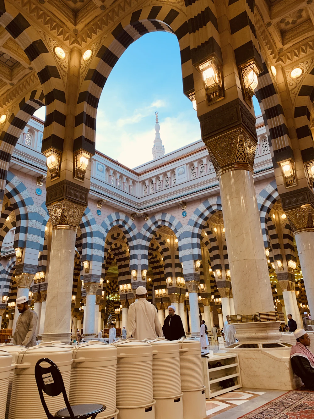Bogen en zuilen in Masjid an-Nabawi, met bezoekers in de zuilengang