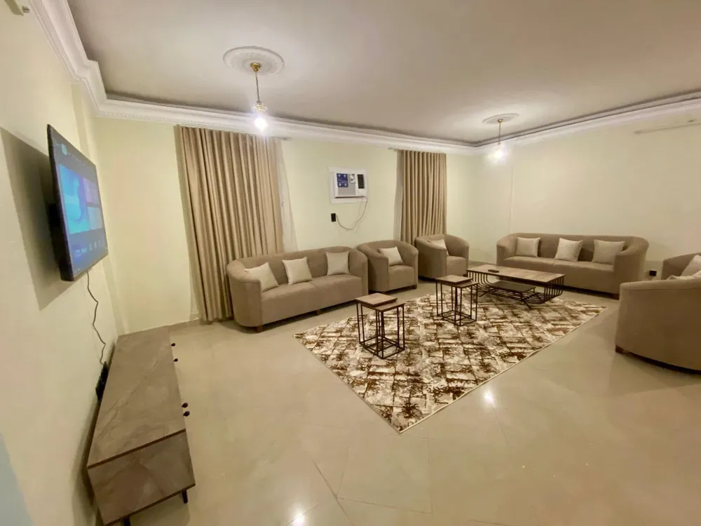 Ruime woonkamer met banken, tv en salontafel in een Premium-appartement